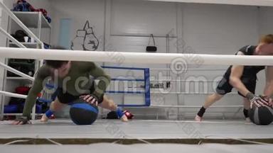 拳击手训练在拳击场上用药球推动运动。 跆拳道男用健身球推着地板